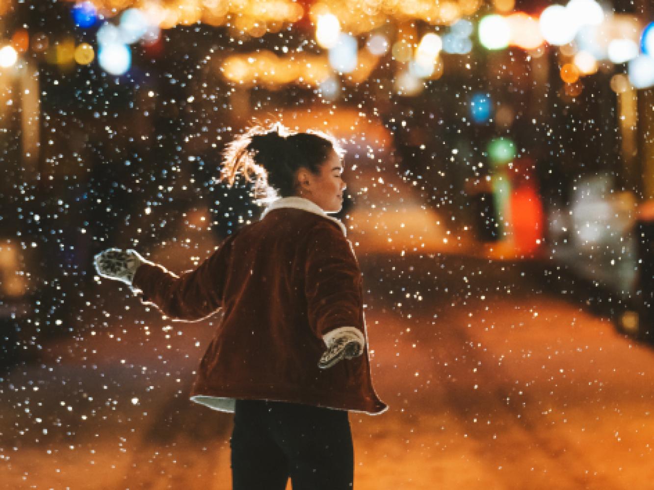 Jente nyter snøvær i Tromsø i jula