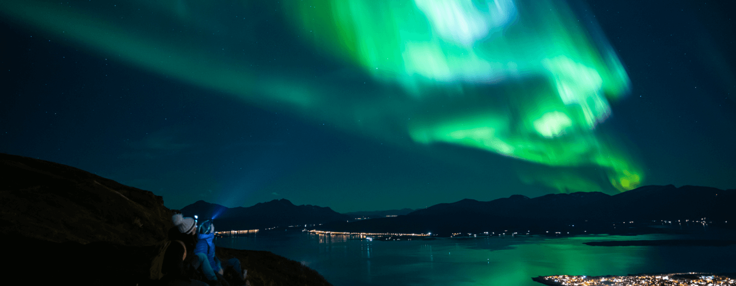 People watching the northern lights over Tromsø city