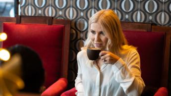 Dame hygger seg med kaffe på en kafé i Tromsø