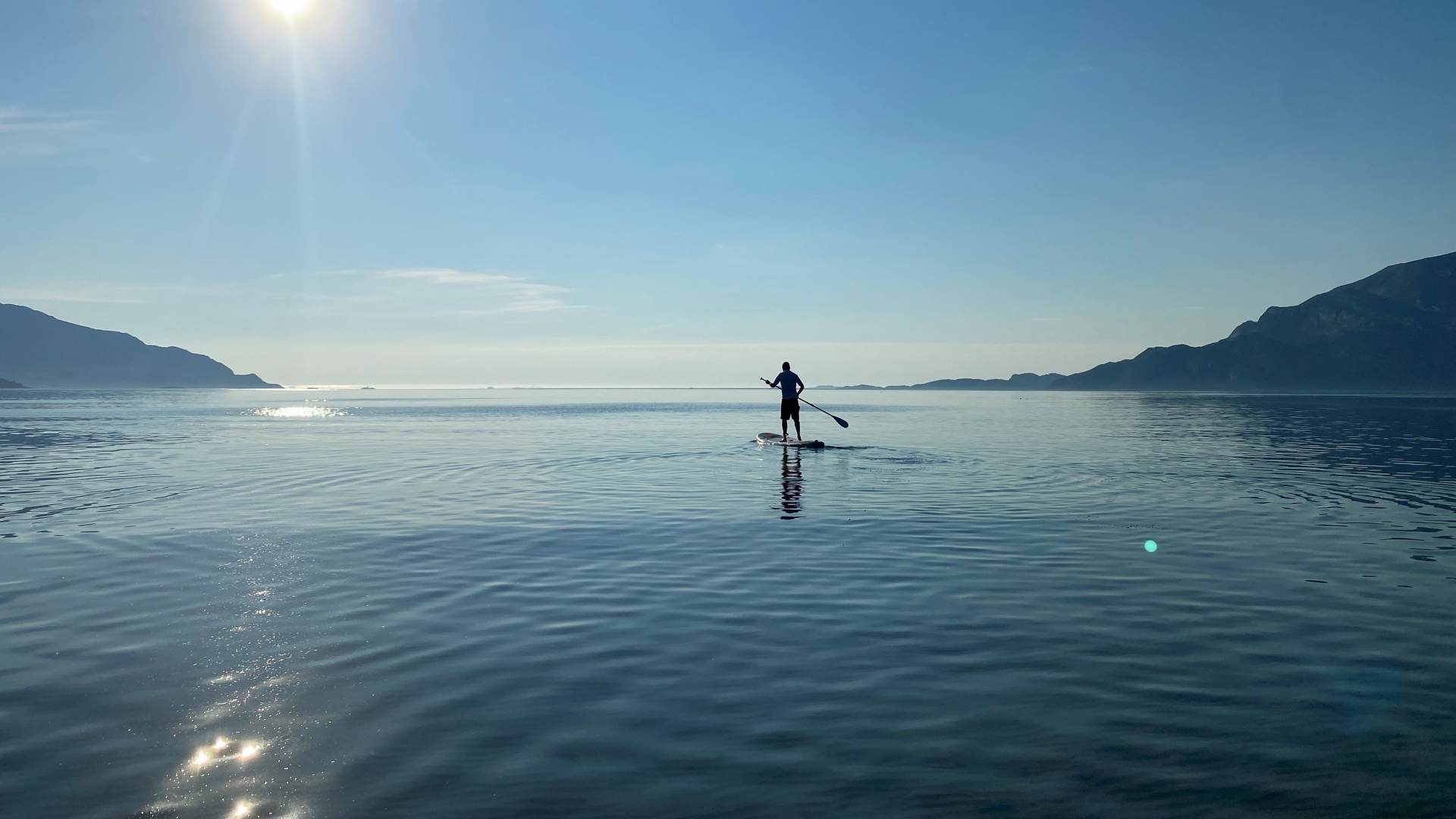 Person doing stand up paddle in Grøtfjord