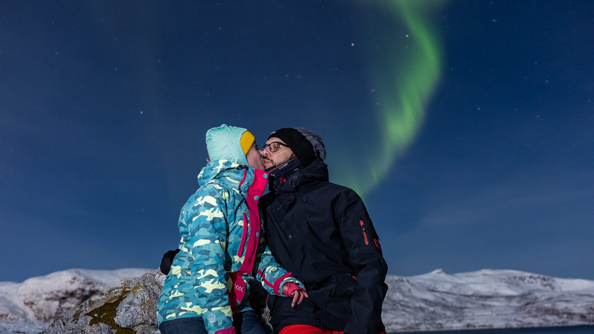 a couple kissing under the northern lights