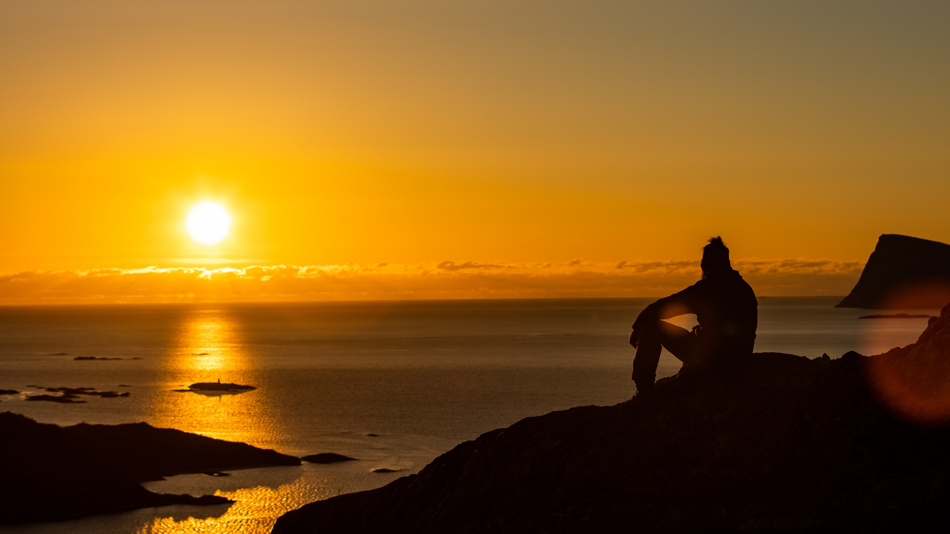 en mann som nyter utsikten over Sommarøy og midnattssolen