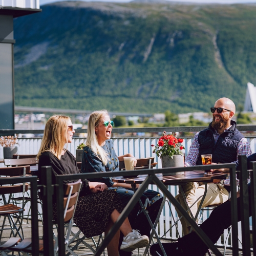 Venner drikker kaffe på utekafé i Tromsø
