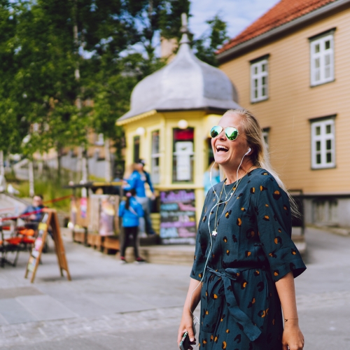 Woman walking past the Rocket kiosk in Tromsø city centre