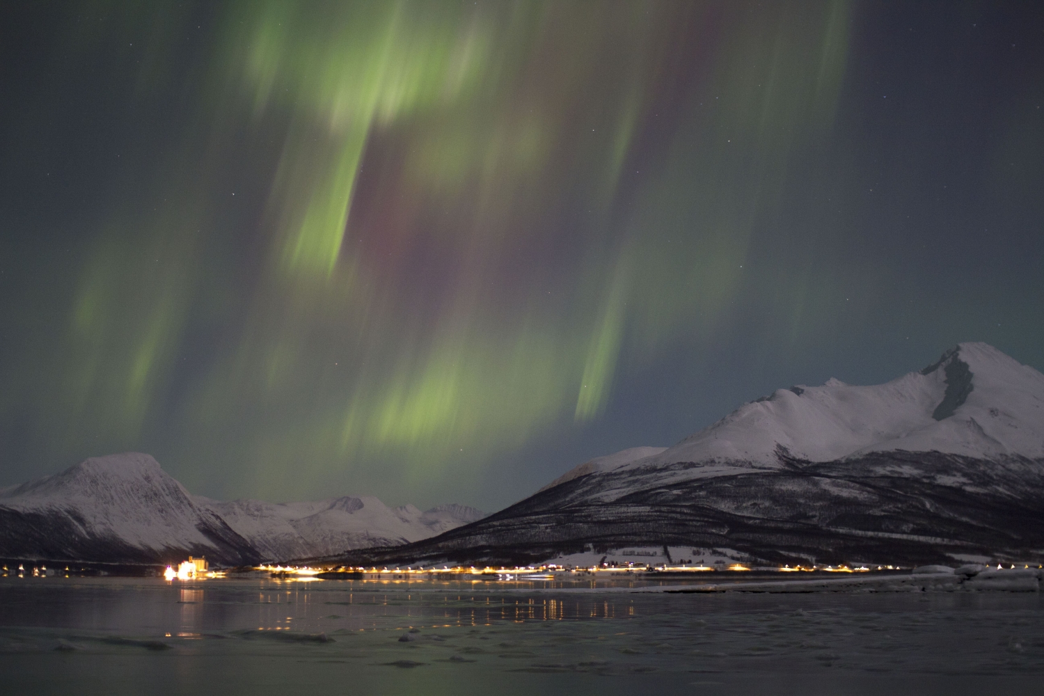 northern lights over the mountains by the fjord