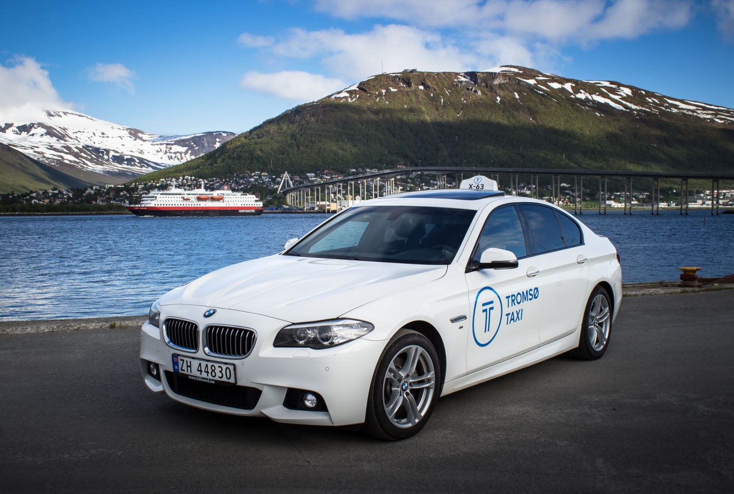 white bmw with the bridge and hurtigruten in the background