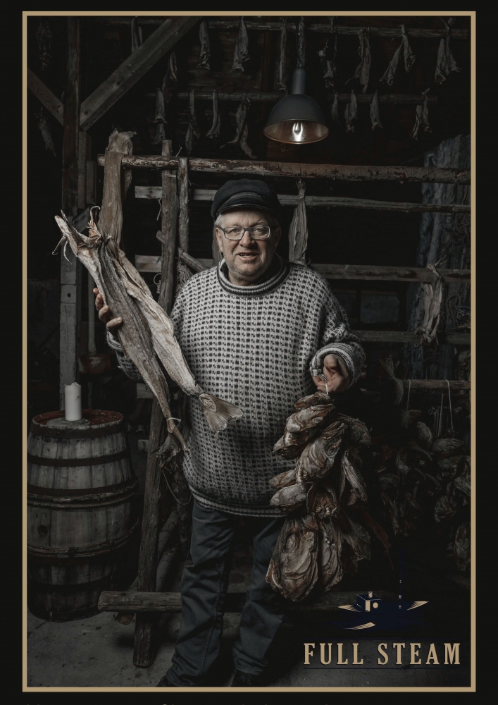 Man in traditional Norwegian clothing holding a stockfish at Full Steam