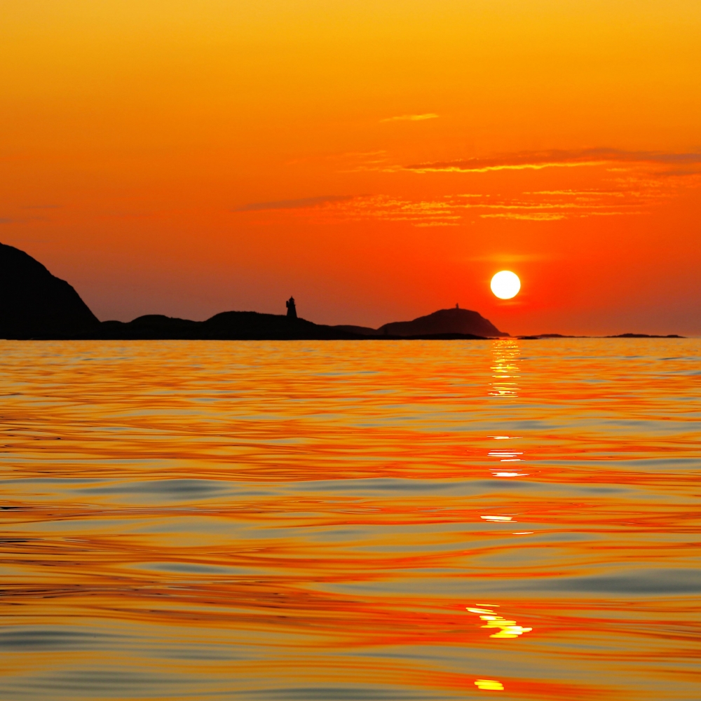 Midnight sun coloring the sky and sea orange