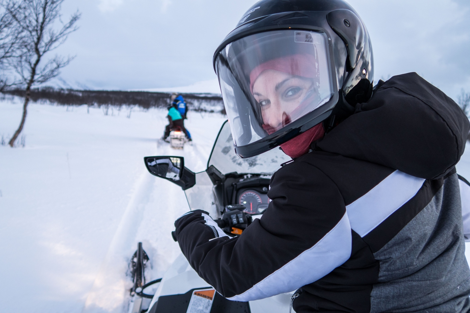 a woman driving a snowmobile