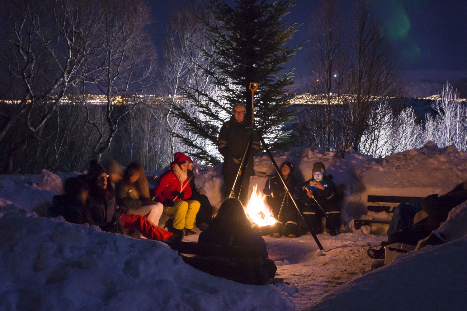 Guests gathered around the bonfire in snowy landscape