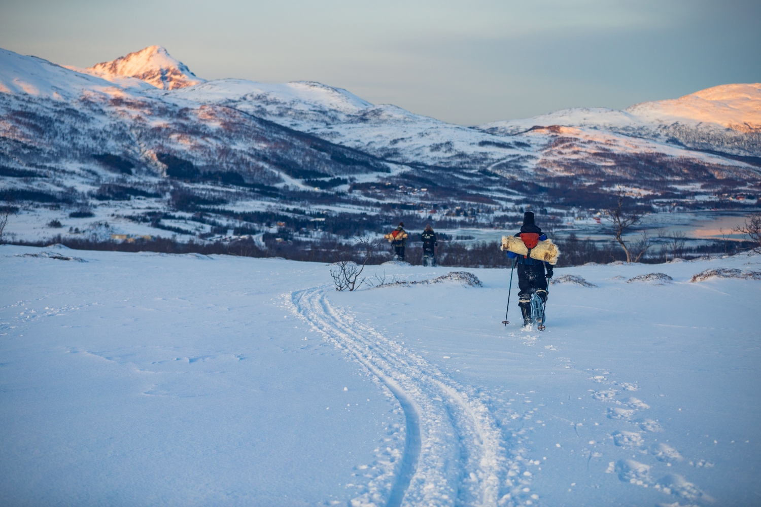 Person som går på truger ved siden av skispor i arktisk vinterlandskap