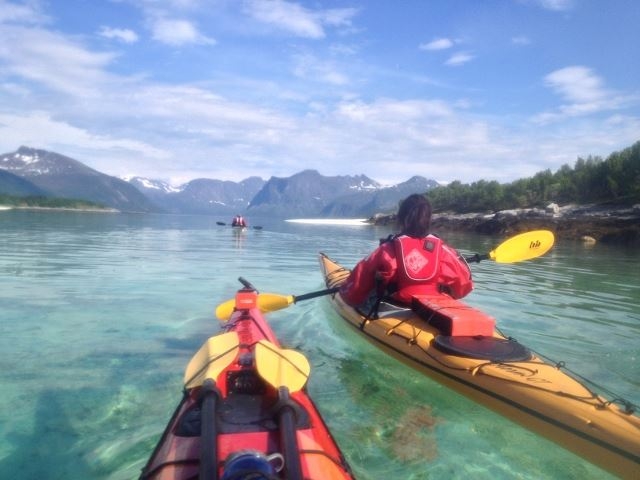Kayaking on turquoise water, mountains in the background
