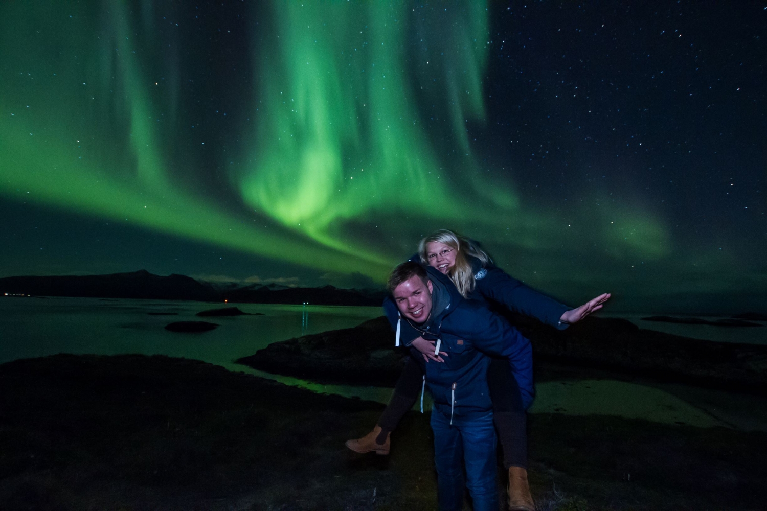 two people posing infront of the northern lights