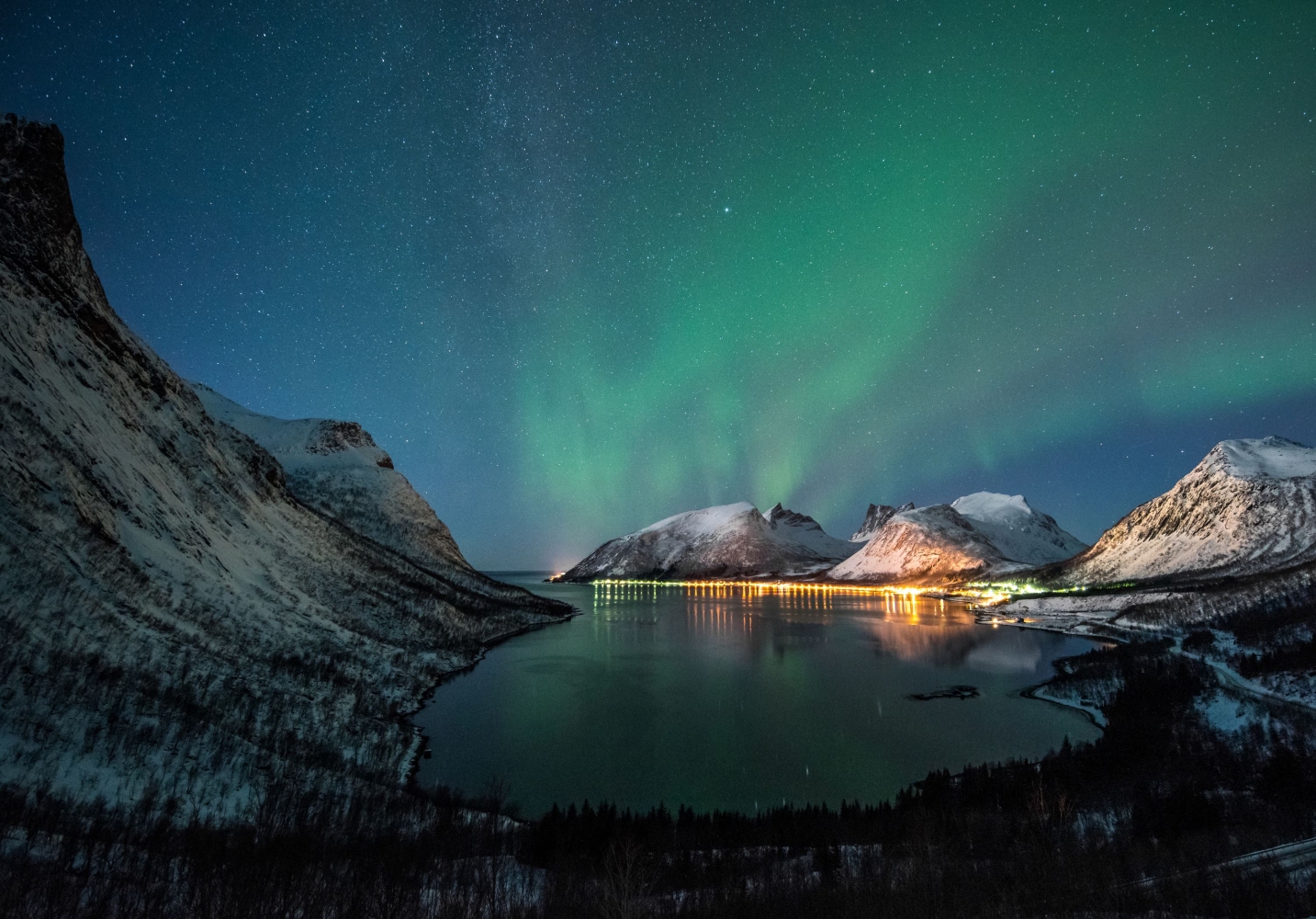 Northern lights above sea and mountains