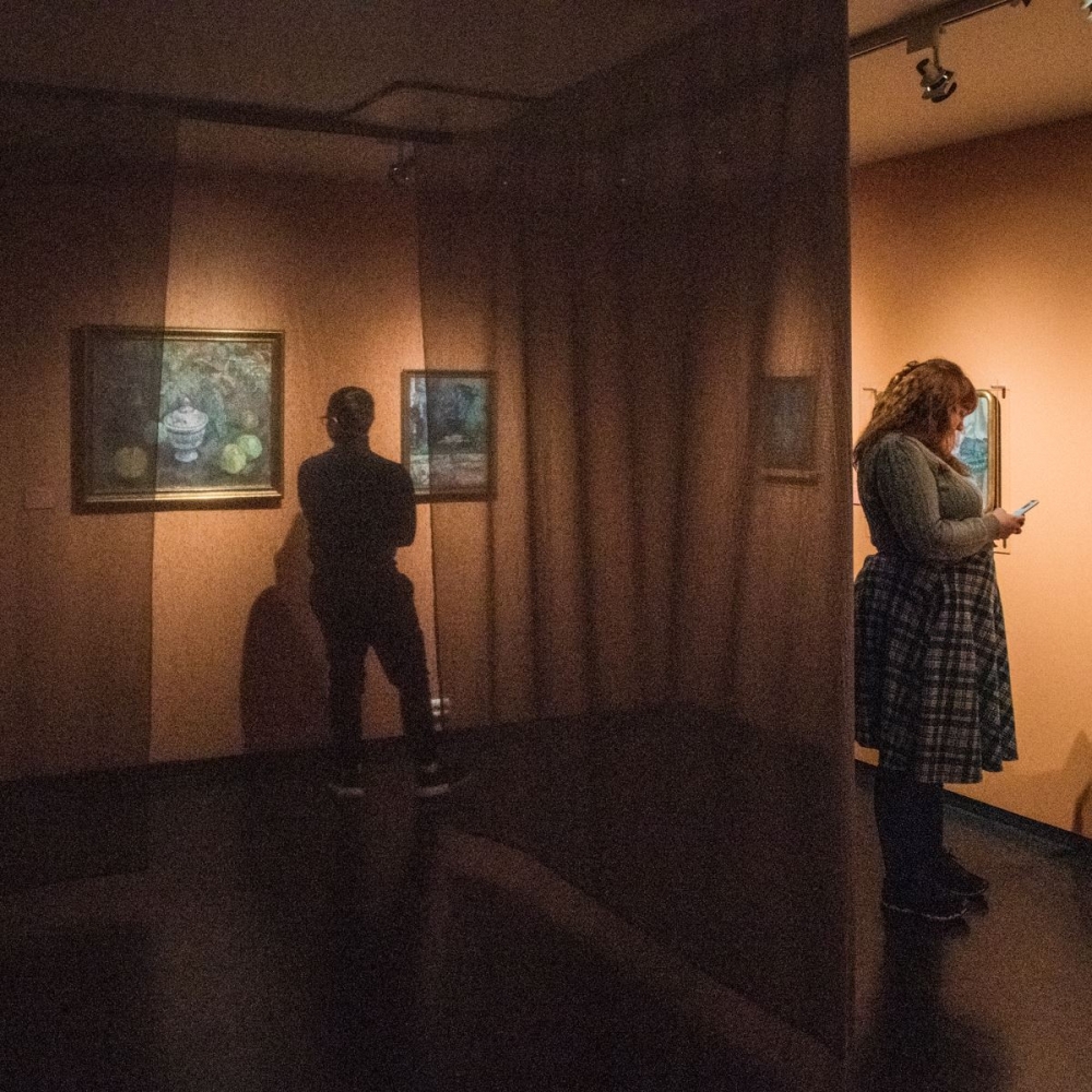 two people inside the museum looking at paintings