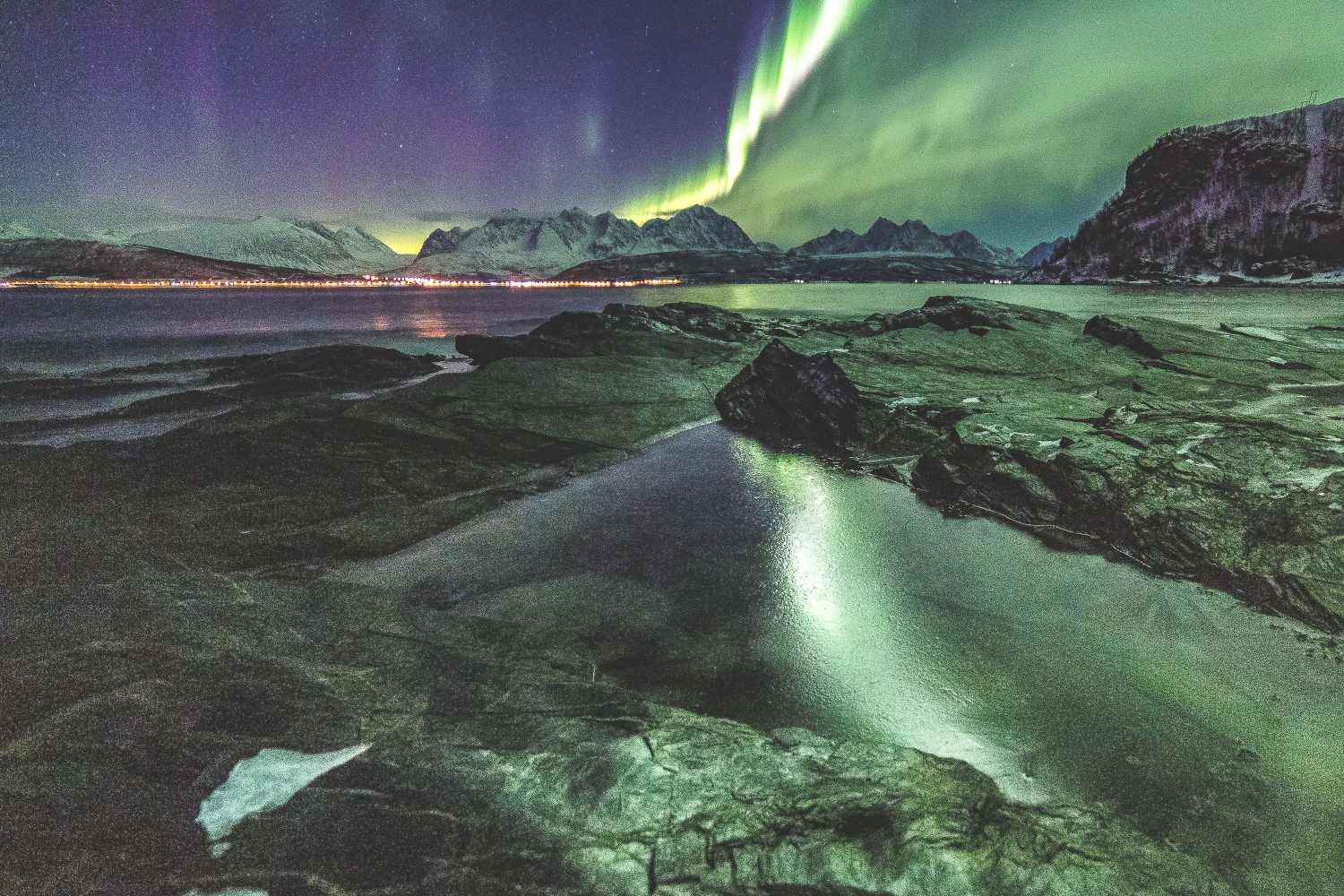 Swirling northern lights reflected over water