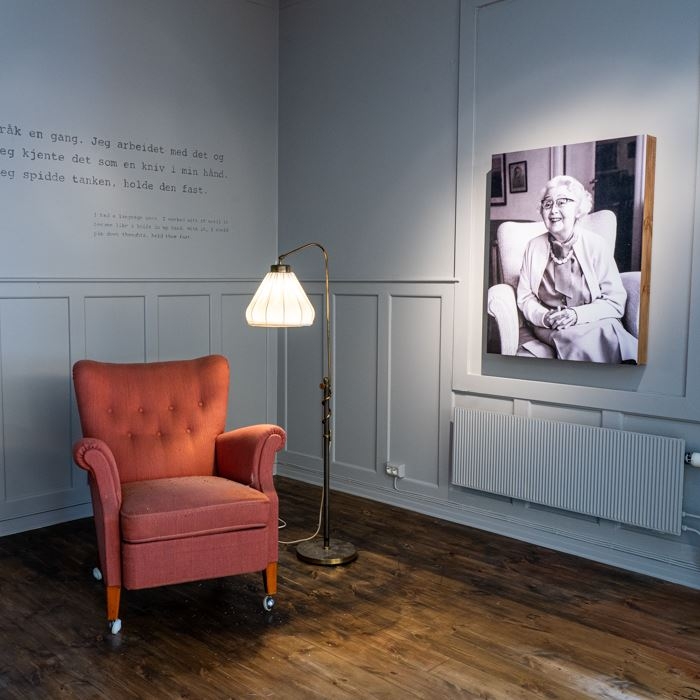 a chair and a photo of Cora Sandel sitting in the chair