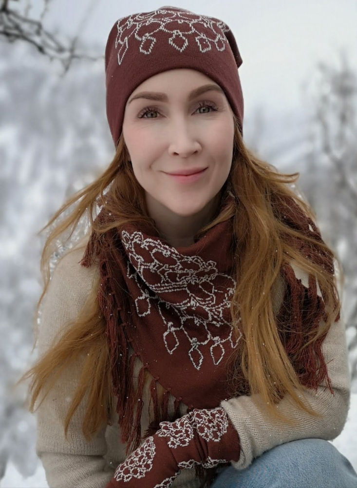 Girl wearing sami design beanie, scarf and gloves