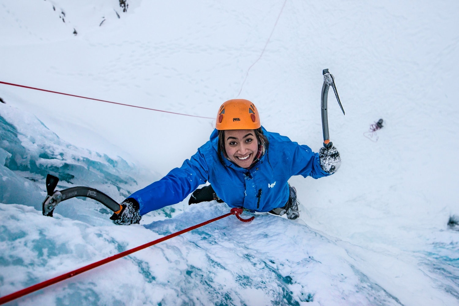 Ei glad jente klatrer opp en isdekt fjellside