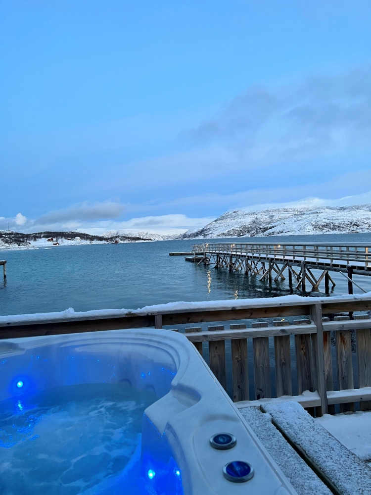 jaquzzi om vinteren med utsikt over fjord og fjell