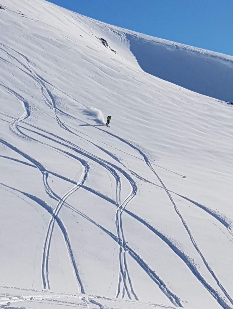 Trails after skiiers down a mountain