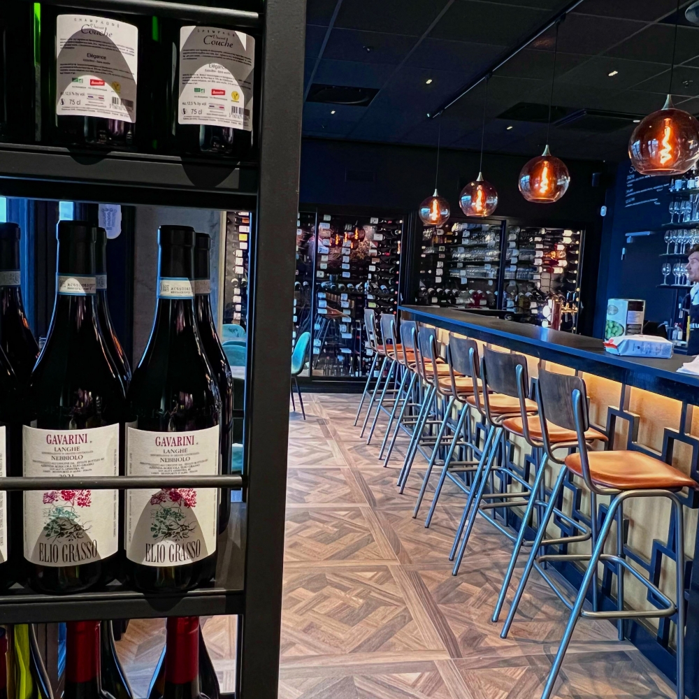 Wine bottles around in the bar on shelves and seatings by the bar