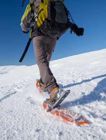 Person snowshoeing on top of a mountain