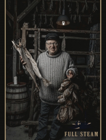 Man in traditional Norwegian clothing holding a stockfish at Full Steam