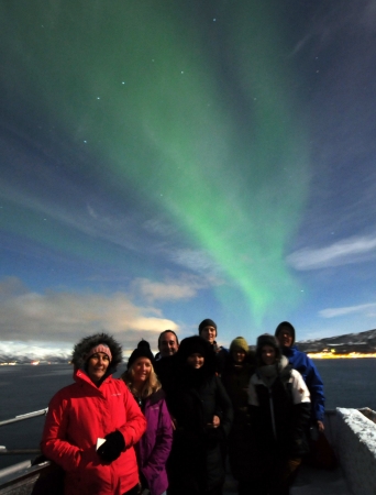 Guests on deck with Northern Lights in the background