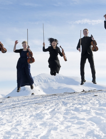 Five happy musicians with imusical nstruments jumping in the snow