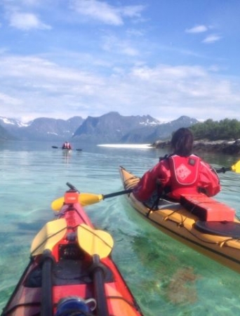 Kayaking on turquoise water, mountains in the background