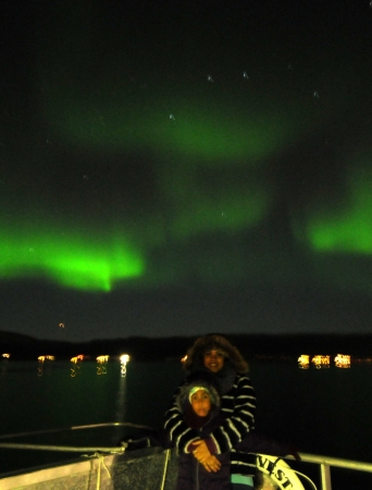 Couple out on deck with the Northern Lights in the background