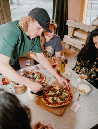 fire personer som spiser pizza