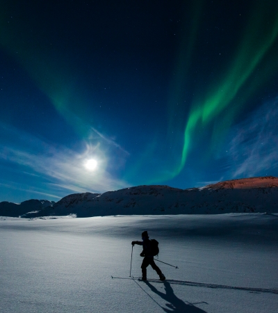 Person går på ski under nordlyset