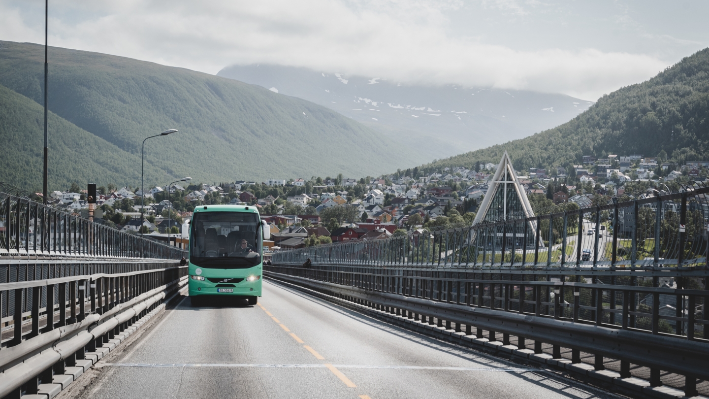 Buss kjører over Tromsøbrua med Ishavskatedralen i bakgrunnen