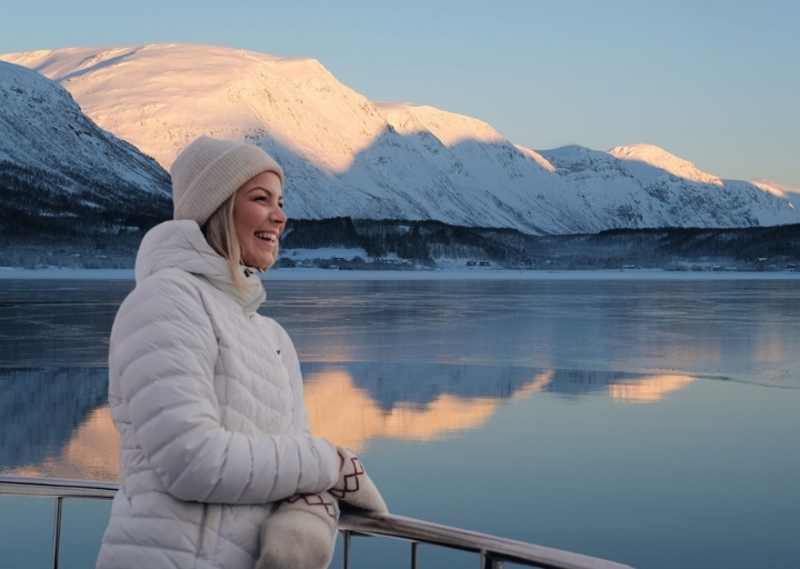 Dame nyter utsikten på et fjordcruise med Rødne i Tromsø-regionen.