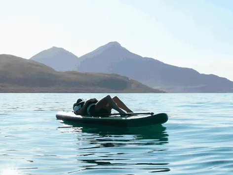 Person on paddleboard relaxing under the sun