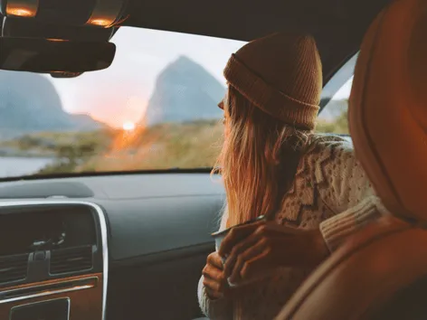 Woman sitting inside a car looking at the view