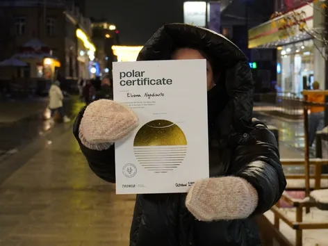 A woman showing her Polar Certificate from Visit Tromsø-Region