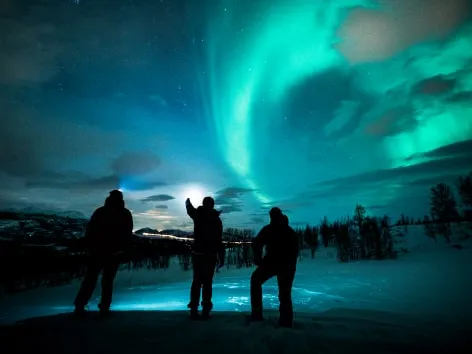 Three people admiring the northern lights