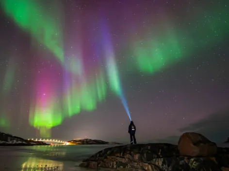 Person looking at Northern Lights with headlamp