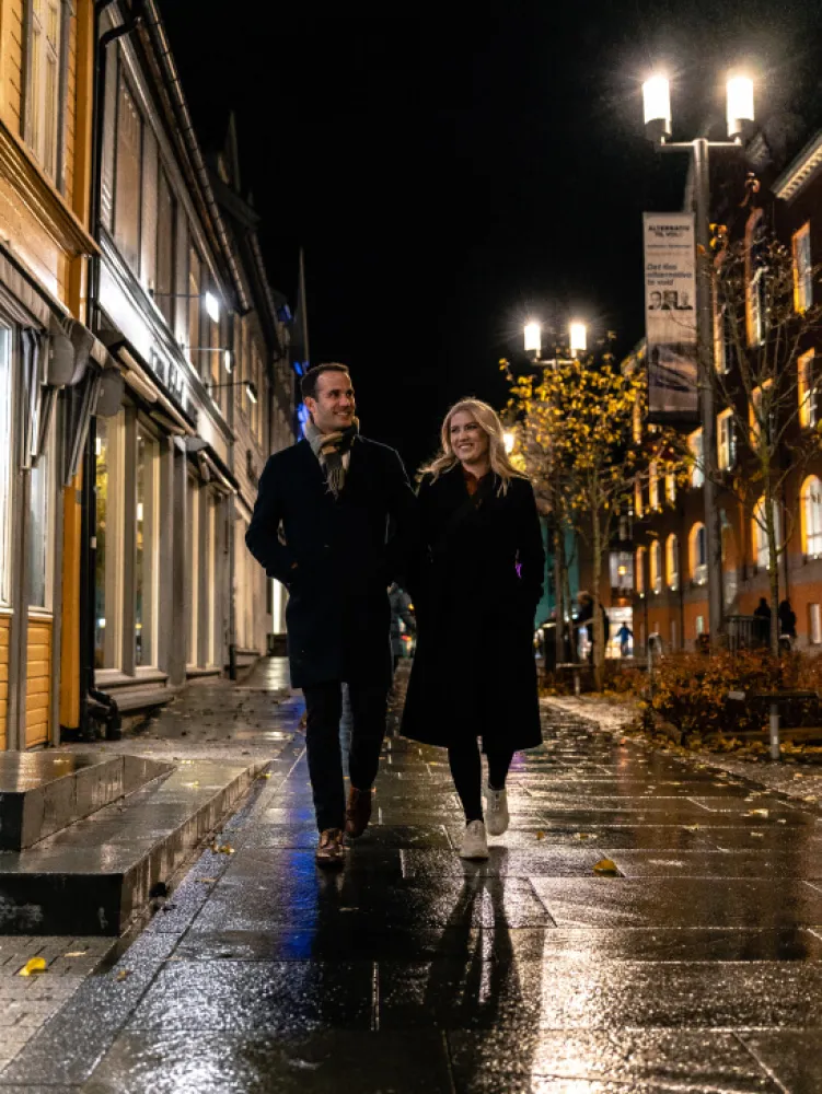 Couple walking on the main street Storgata in Tromso in autumn