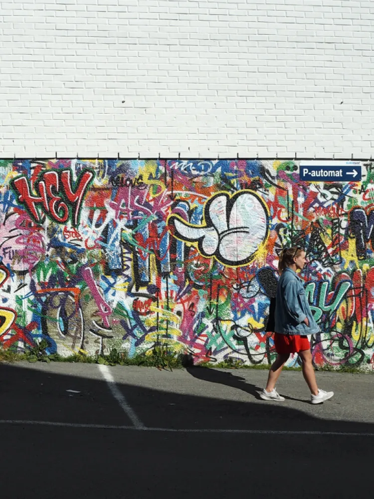 Lady walks in front of street art in the city centre