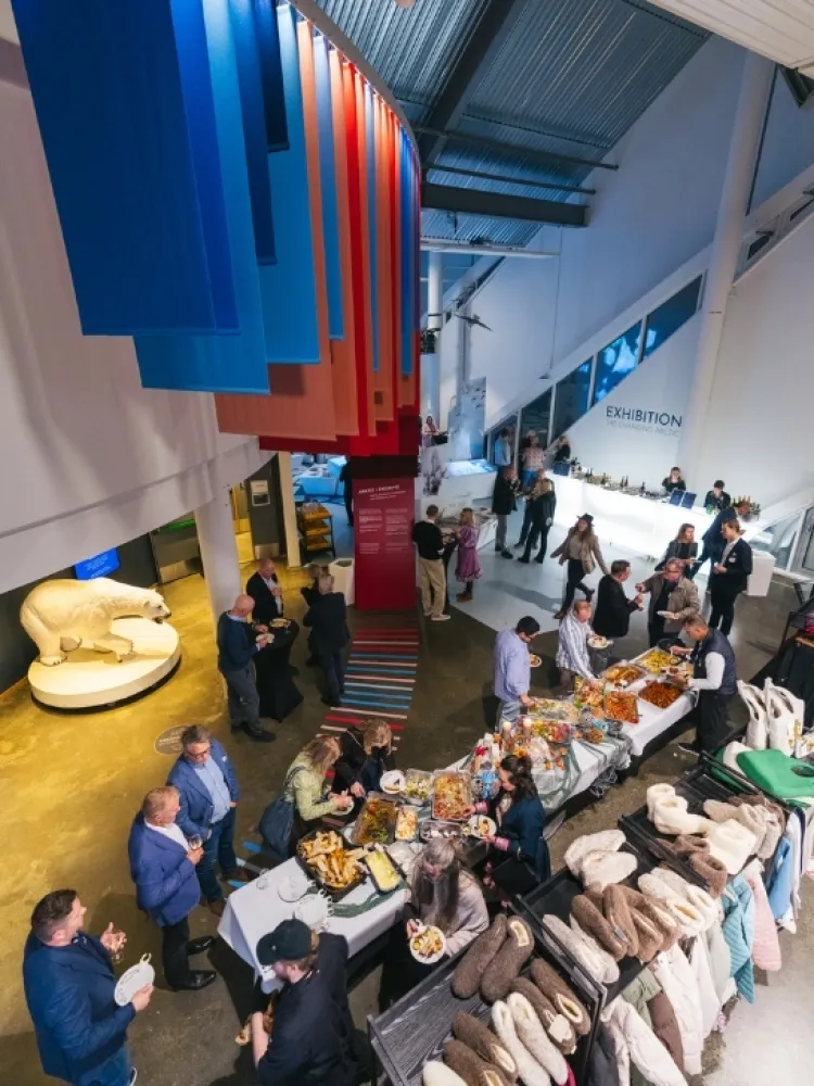 Gjester samlet til et arrangement med buffetservering i utstillingslokalene på Polaria i Tromsø.