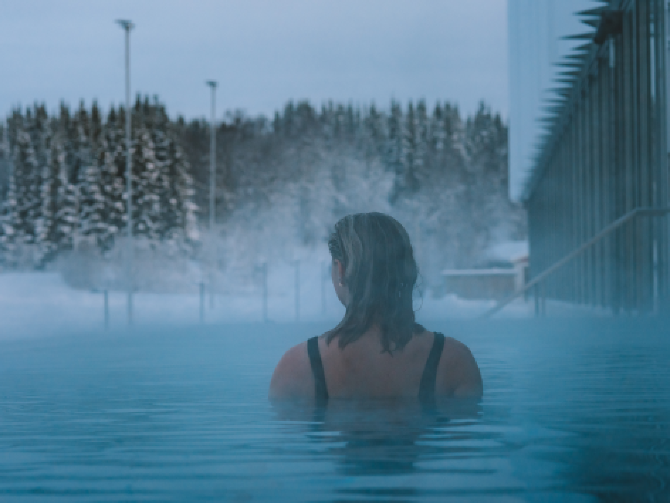Woman swimming in heated pool in winter