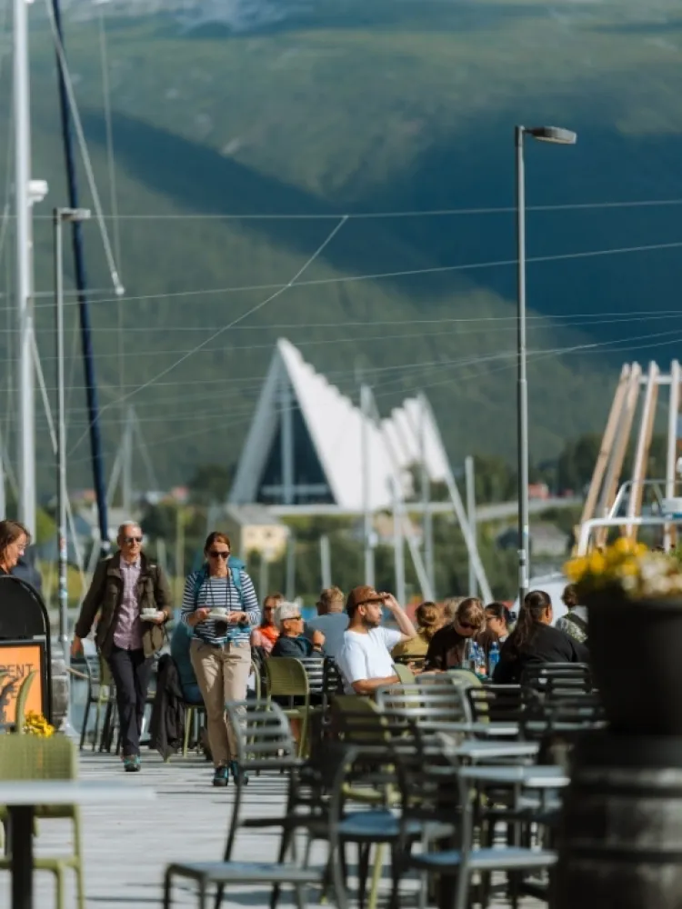 People enjoying themselves at an outdoor café on a sunny day in Tromsø