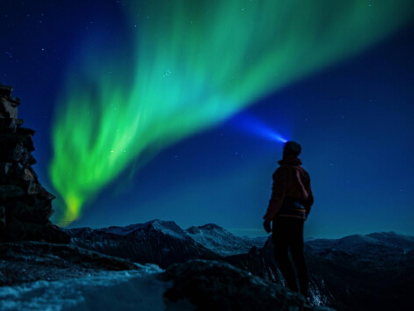 Man in mountains see Northern light