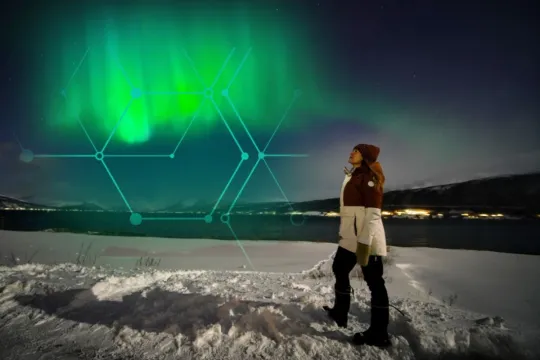 A guest looks up towards the Northern Lights