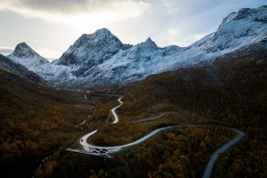 A road on Senja with snow covered mountains in the background
