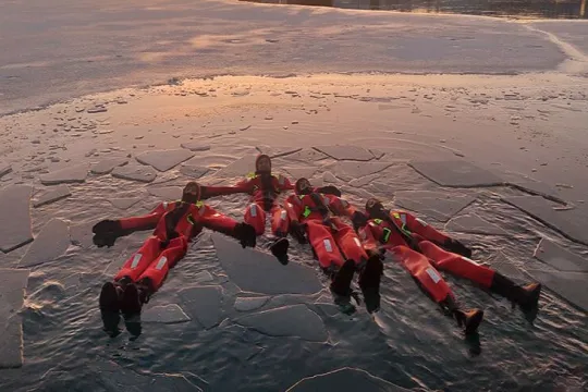 Flere gjester som flyter i vannet med is